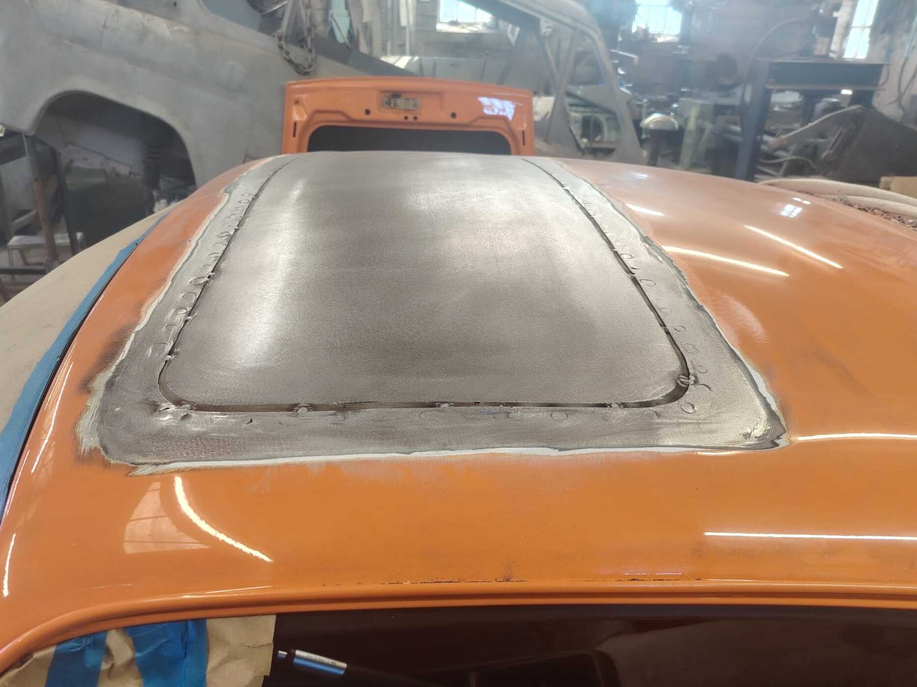 Porsche 911 roof with the sunroof aperture filled by a hand-formed panel