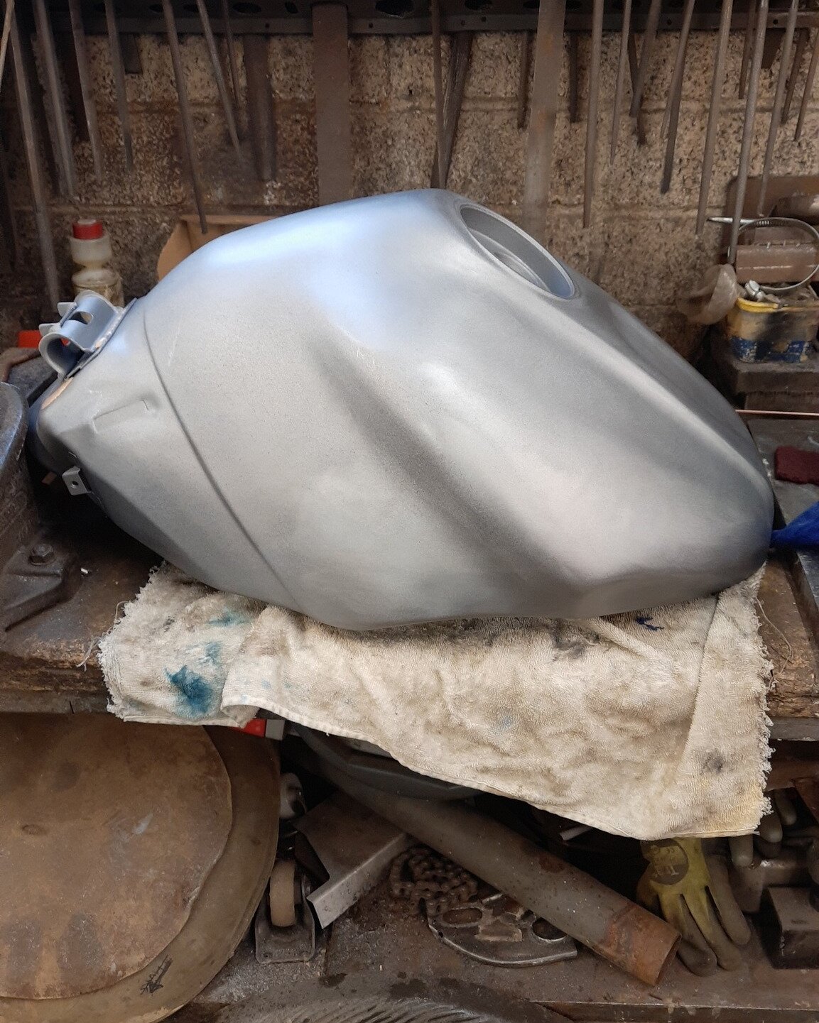 The same Yamaha fuel tank repaired, back on the bench in bare steel ready for paint